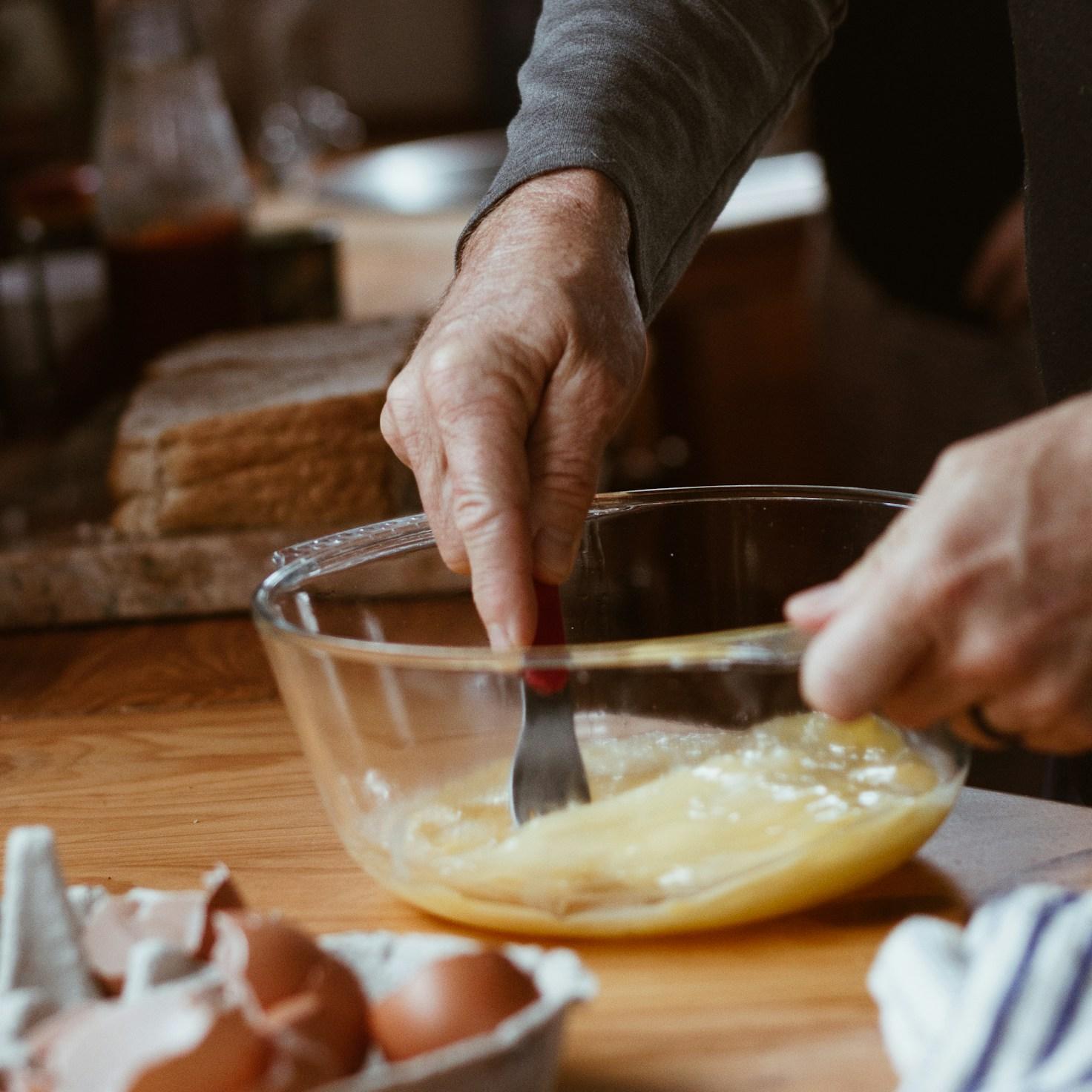 People collaborating in a modern kitchen, exchanging recipes and techniques